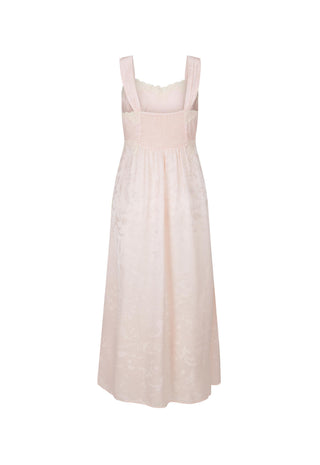 A light pink sleeveless midi dress with a smocked bodice, wide shoulder straps, and a subtle tonal floral jacquard pattern, shown against a plain white background.