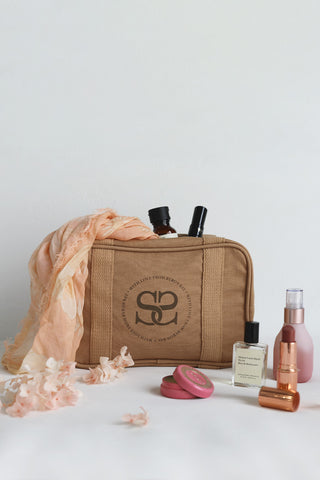 an-image-of-the-spell-curators-club-cosmetic-bag-surrounded-by-cosmetics-and-the-sloan-travel-scarf